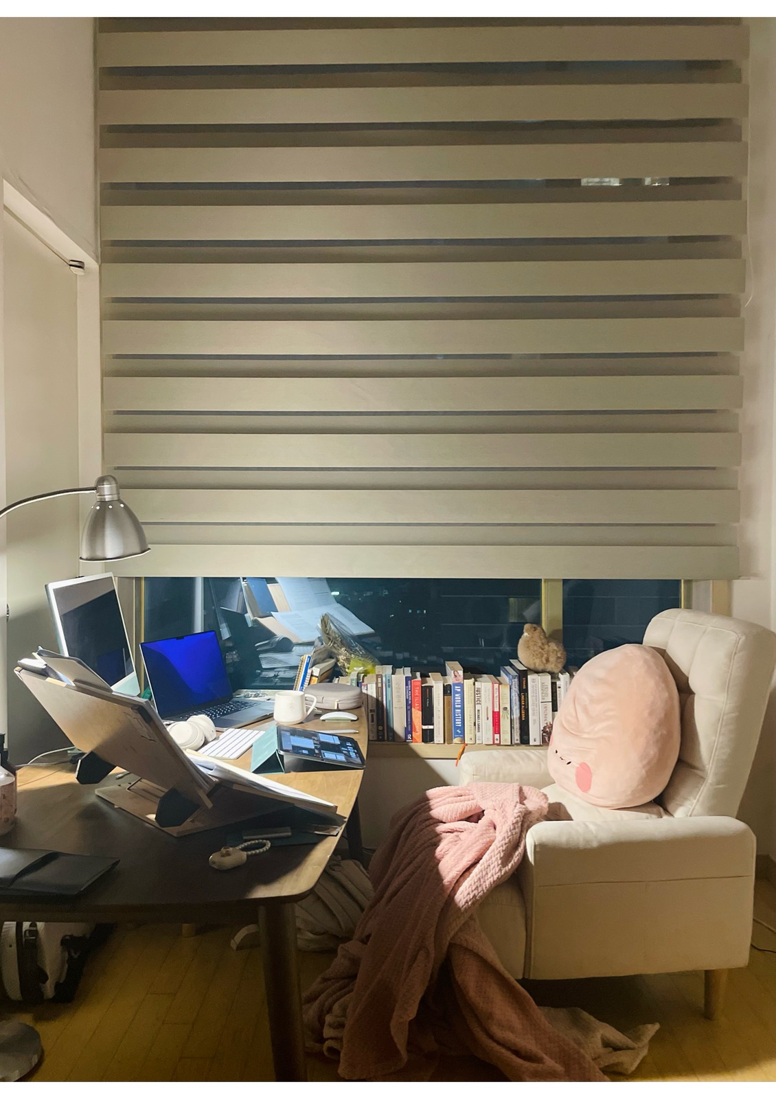 Study nook at night — desk, books, and armchair